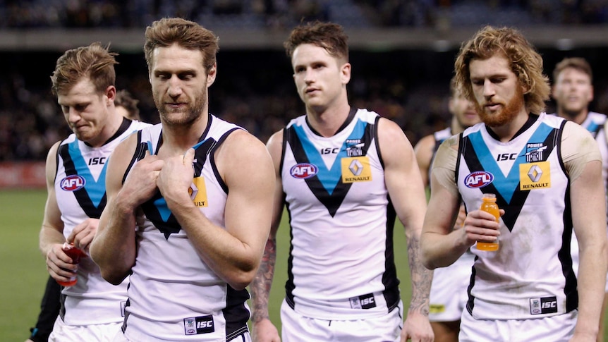 Dejected Port Adelaide players leave the field