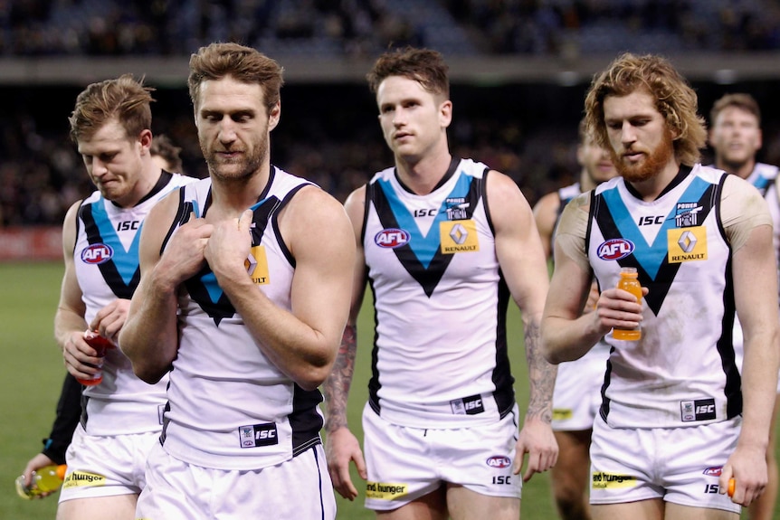 Dejected Port Adelaide players leave the field