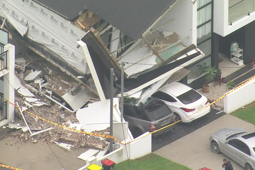 a house collapsed with cars under the wreck