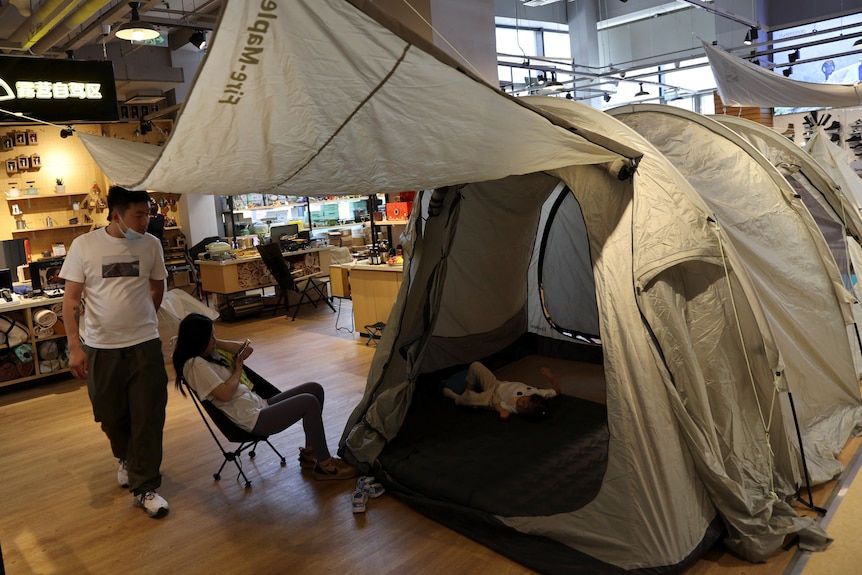 Beijing residents looking at a brown tent in camping stores 