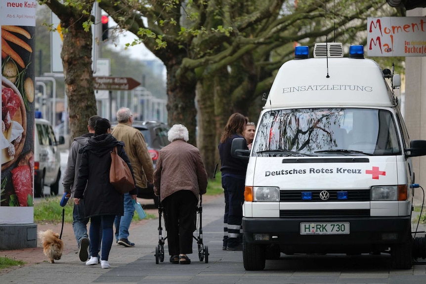 Evacuees gather around German Red Cross ambulance in Hannover