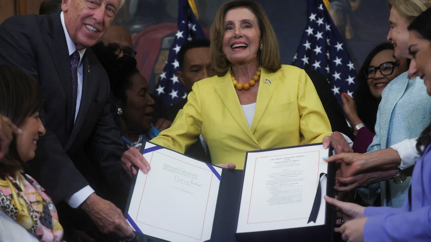  House members hold a signed copy of the "Inflation Reduction Act of 2022," at an enrollment ceremony 