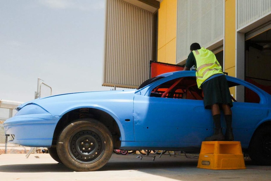 A man works on a speedway car