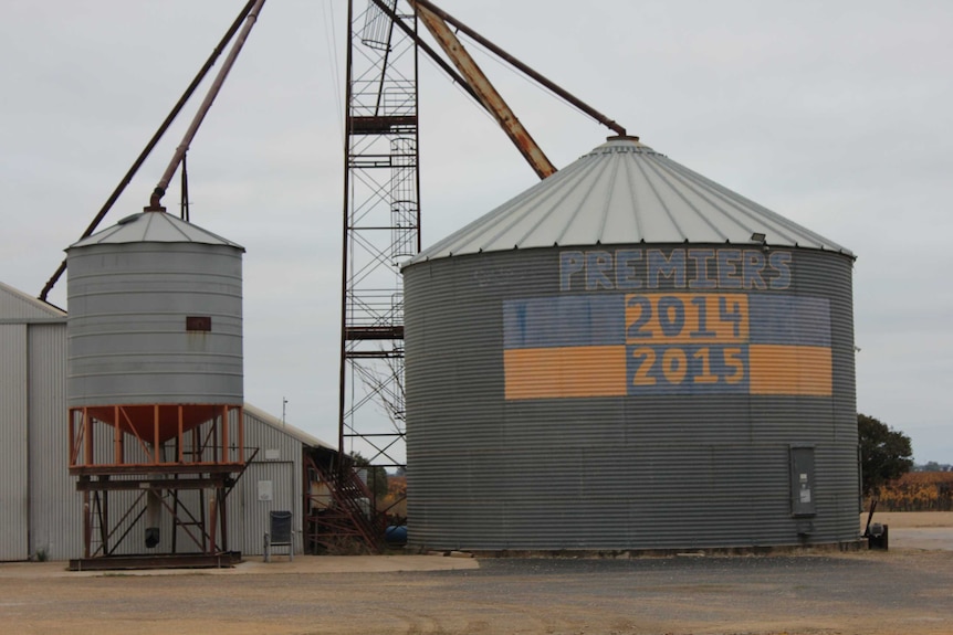 Outside of silo painted blue and yellow checks with the words "premiers 2014, 2015"