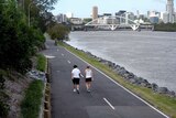 Two women and a cyclist make their way along the Coronation Drive bikepath/walkway