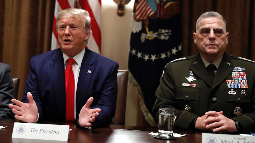 Donald Trump, sits next to General Mark Milley.