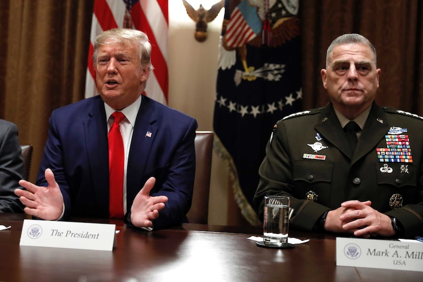 Donald Trump, sits next to General Mark Milley.