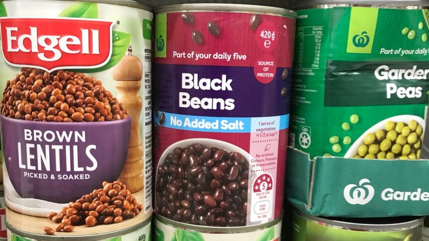 A range of tinned beans on the supermarket shelf at Woolworths
