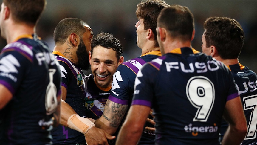 Billy Slater of the Storm celebrates with his teammates after scoring a try.