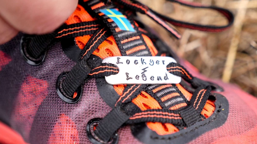 A metal tag on running she laces says Lockyer Legends