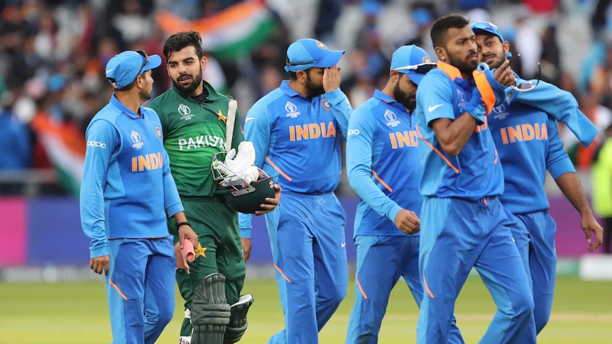 Cricket players from both teams walk off the ground after a World Cup match.