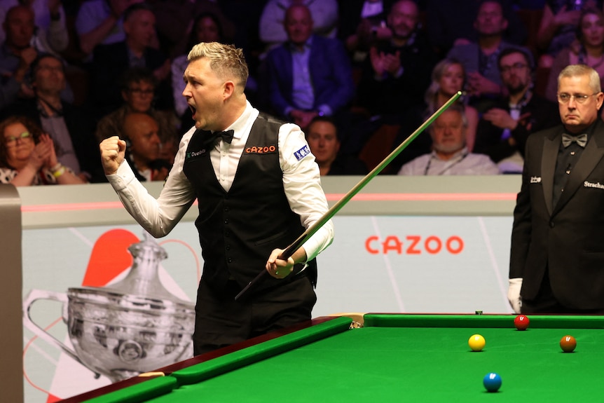 Snooker player Kyren Wilson pumps his first at the table, celebrating a victory