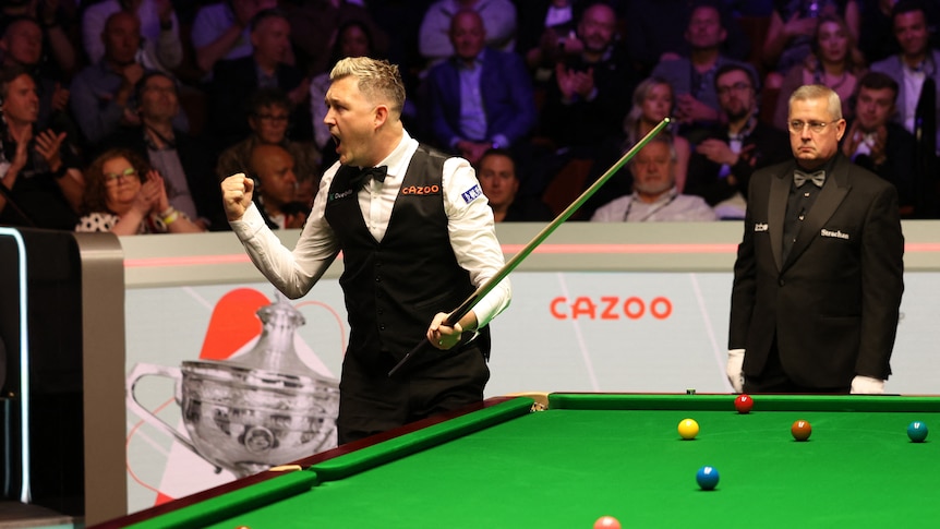 Snooker player Kyren Wilson pumps his first at the table, celebrating a victory