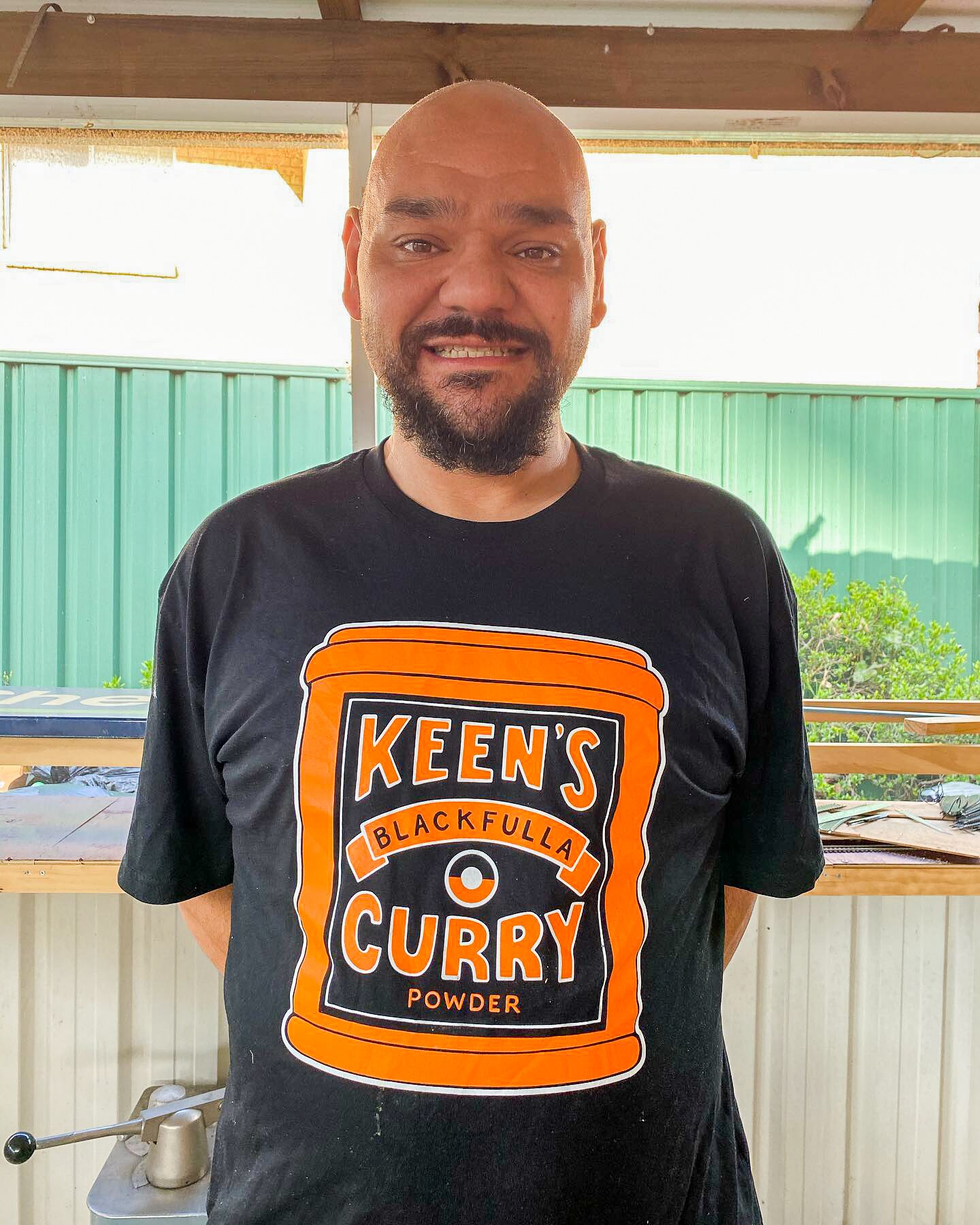 Nathan Lyons standing in the kitchen wearing black tee