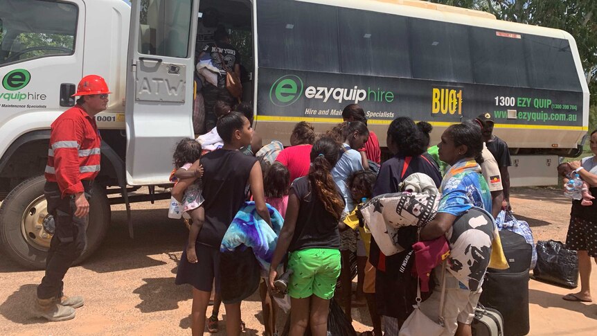 Residents lineup to get on a bus at Borroloola.