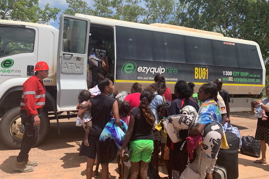 Residents lineup to get on a bus at Borroloola.