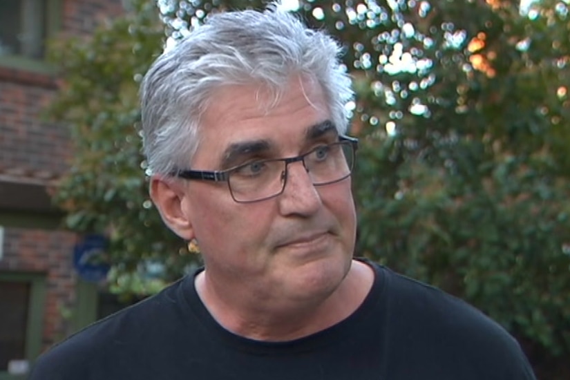 A man with grey hair and glasses