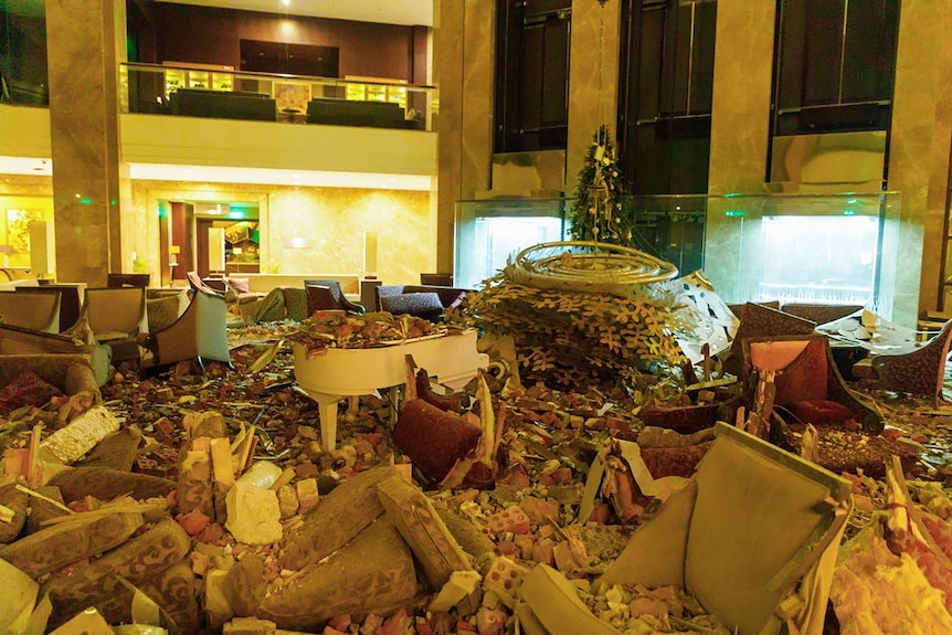 The inside of a hotel lobby with debris all over the ground.