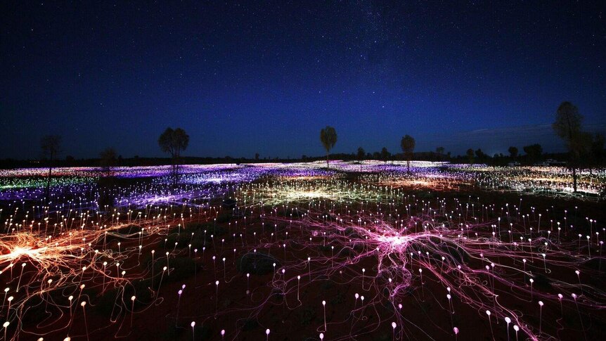 aerial view of field of light at Uluru, lit up in the darkness