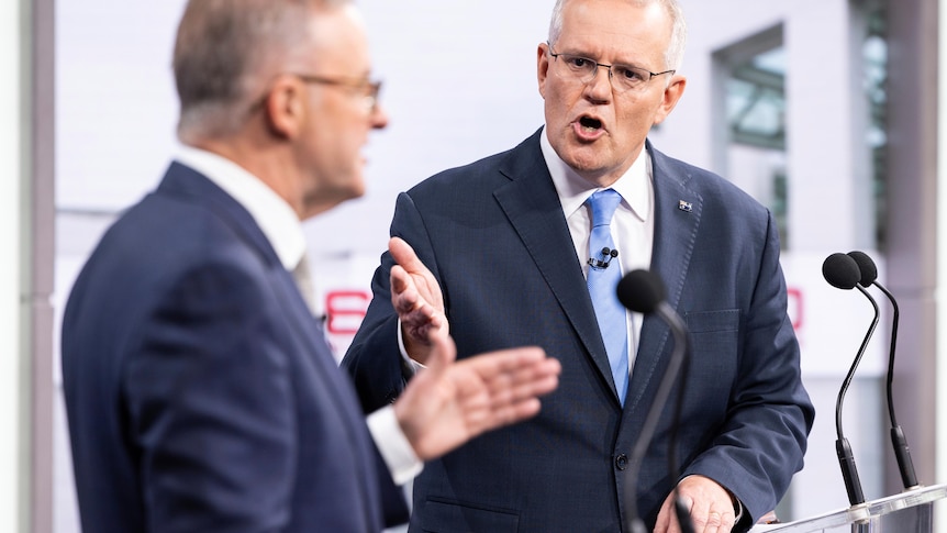 Morrison, in focus, gestures as he speaks to Albanese