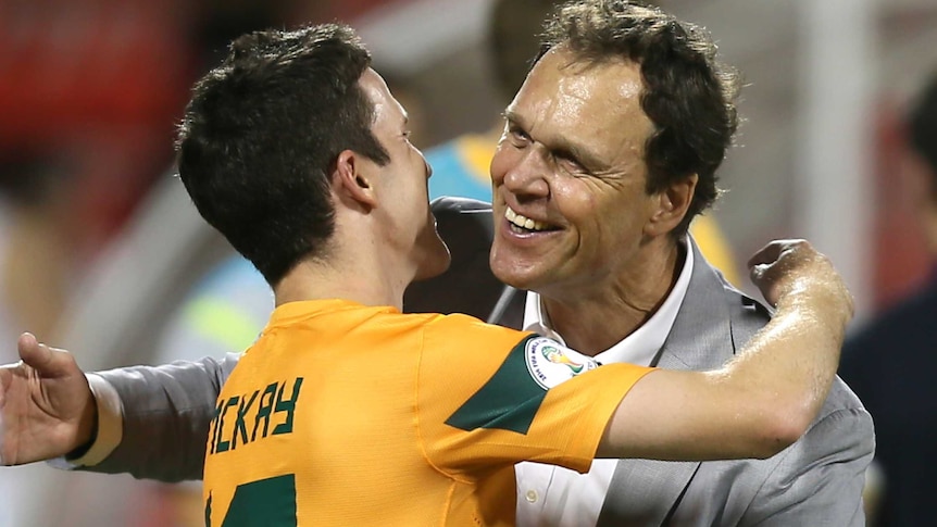 Holger Osieck hugs Matthew Mckay after 2-1 win over Iraq.