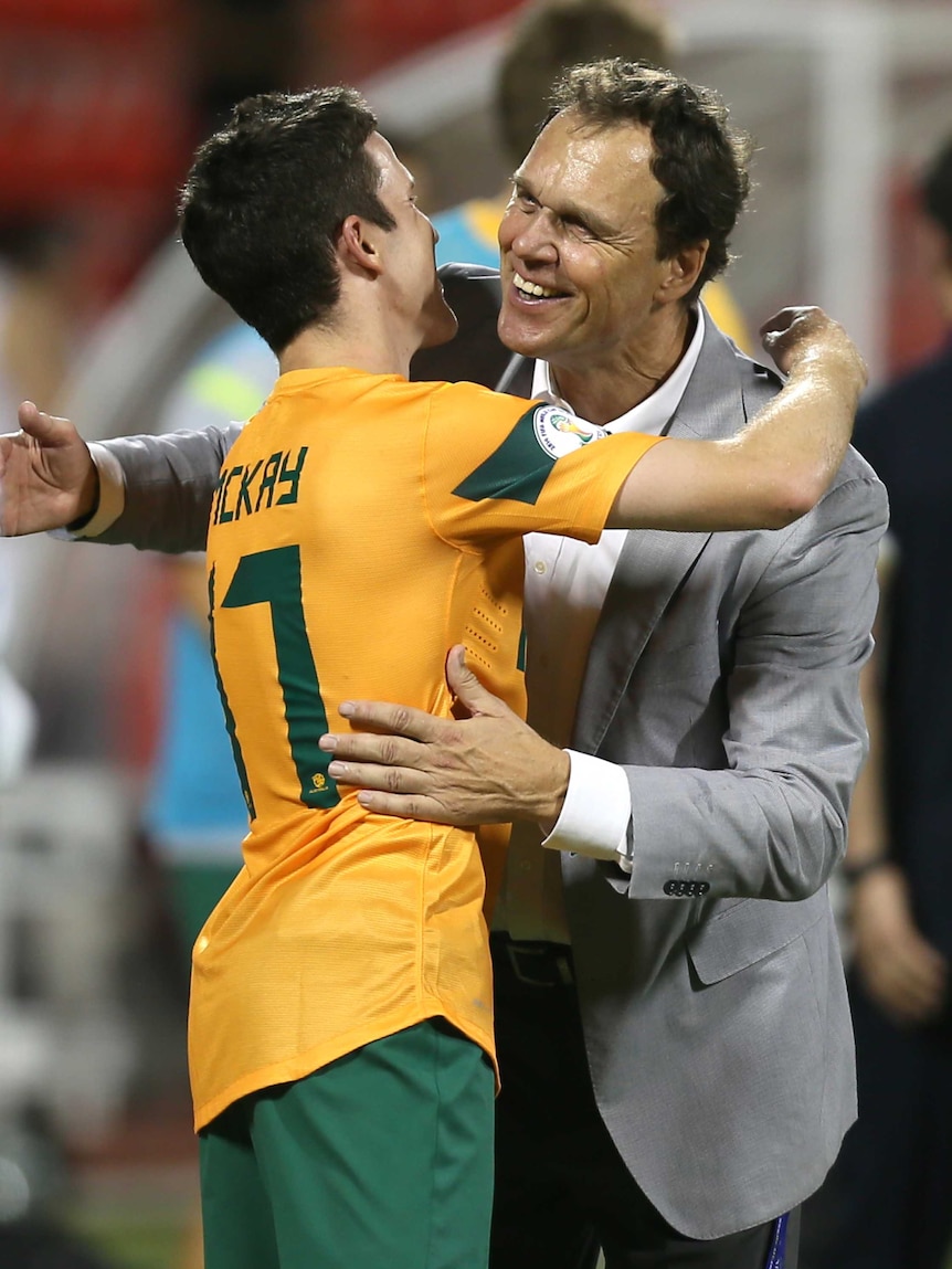 Holger Osieck hugs Matthew Mckay after 2-1 win over Iraq.