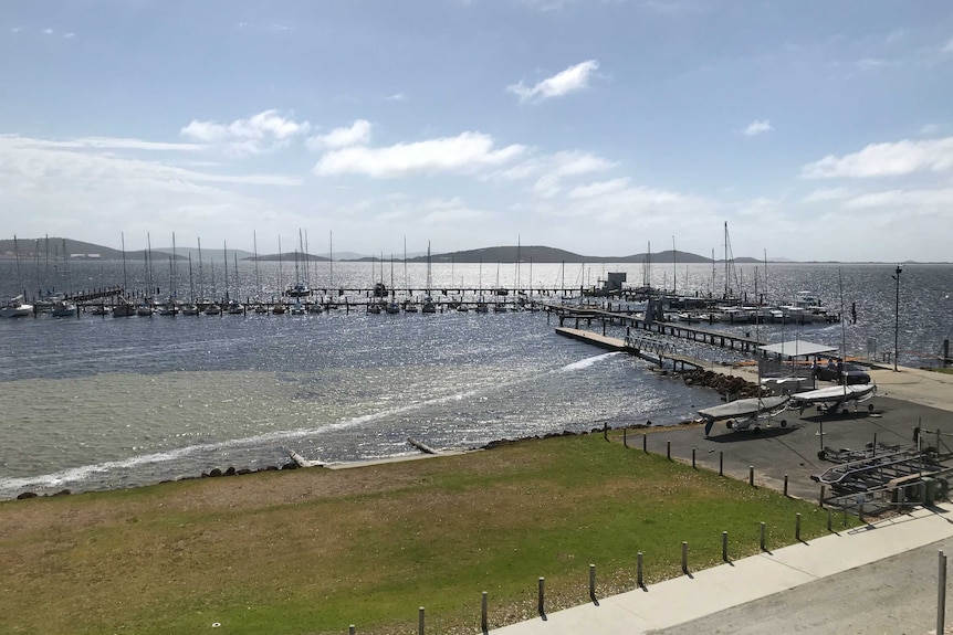 A wide shot of Princess Royal Sailing Club in Albany showing boats in the harbour under a blue sky.