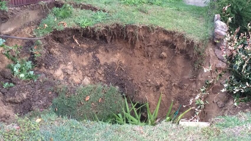 The Resources Minister Anthony Roberts surveys repair work at the site of two sinkholes in Swansea.