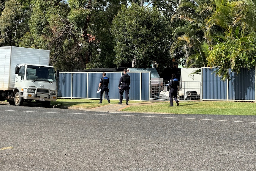 Three police officers walk down a surburban street
