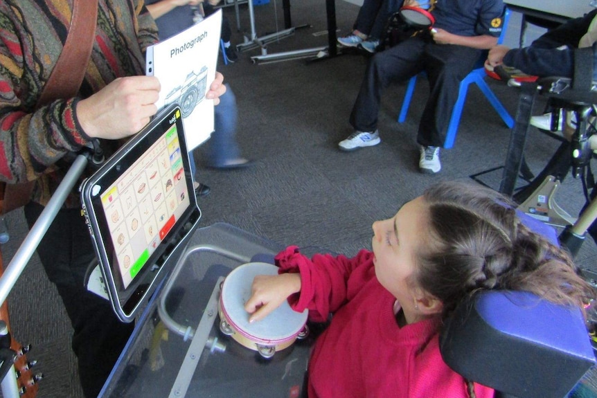 A girl in a wheelchair using a computer