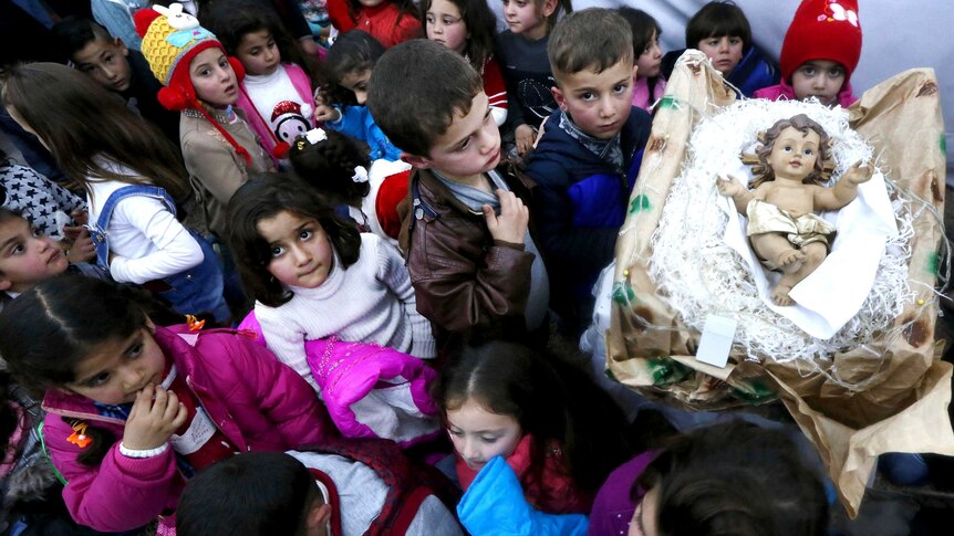 Iraqi Christian children gather around a manger holding the baby Jesus in the Ashti camp in Arbil, northern Iraq.