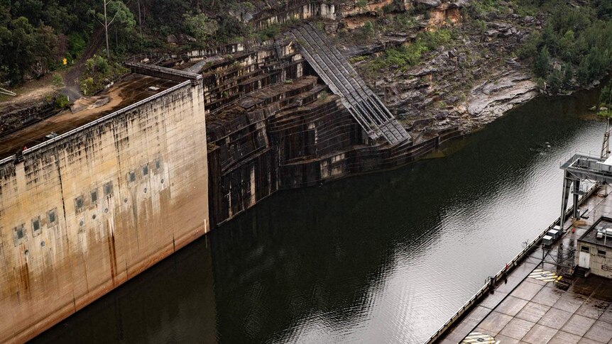 Parts of the dam wall can be seen near the edge of the water storage facility.