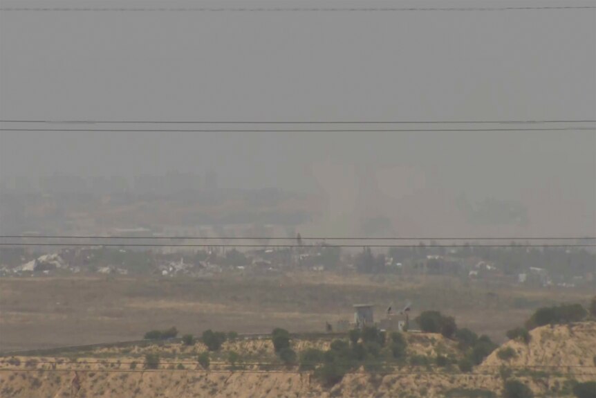 A screenshot of a video feed shows smoke rising from Gaza