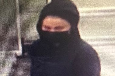 A person dressed in black with face covering captured on CCTV