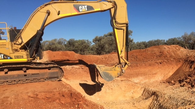 A bob cat digs dirt at the Ammaroo phosphate mine