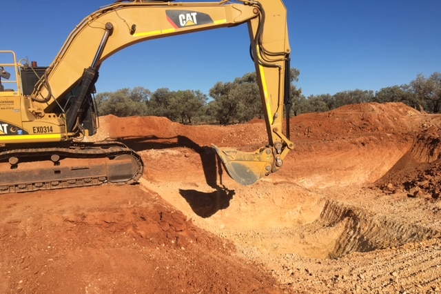 A bob cat digs dirt at the Ammaroo phosphate mine