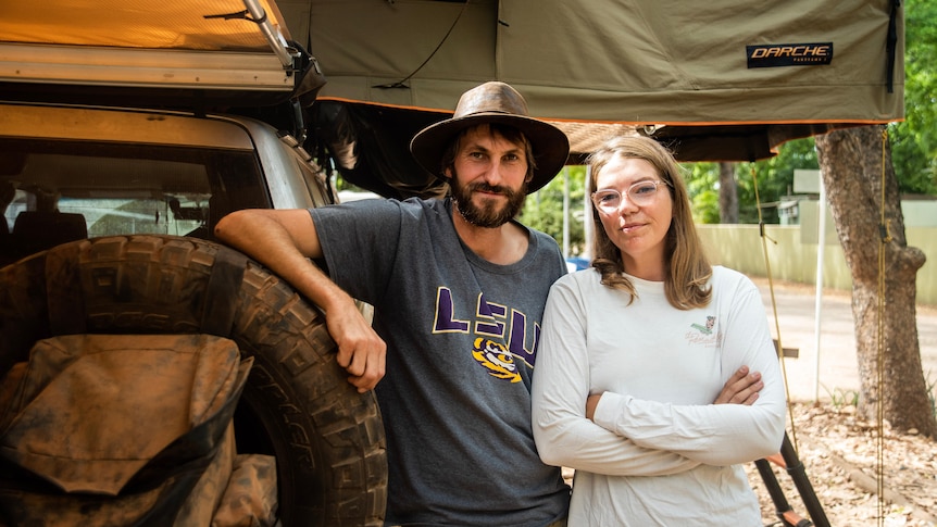 A couple stands at the end of a dirty four-wheel-drive