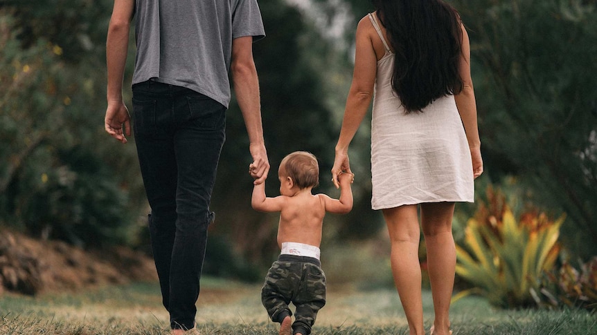 Man, woman and baby walk along holding hands in a story about the expectations and pressure to have sex after childbirth.