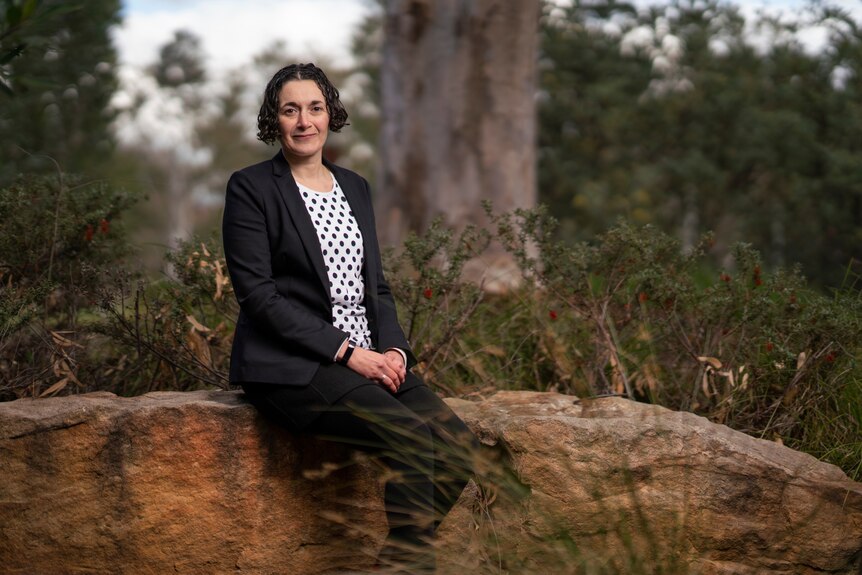 Dr Joelle Gergis sits on a rock
