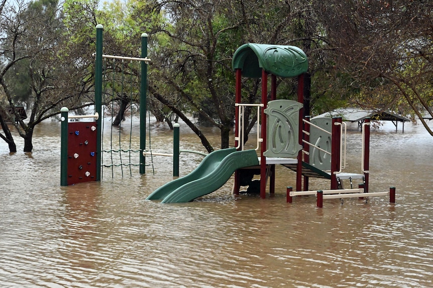 Un patio de recreo está medio sumergido en las crecientes aguas de la inundación.