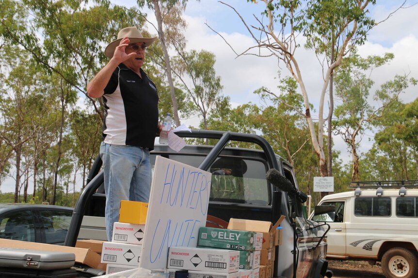 Bart Irwin stands on the back of a ute to speak to a crowd.