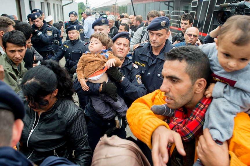 Police help children and mothers to board a train in Nickelsdorf, Austria