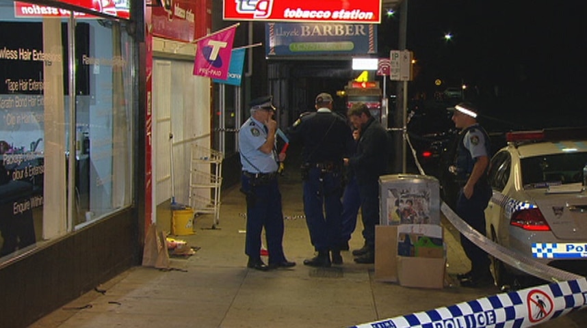 Police officers stand outside a tobacconist store