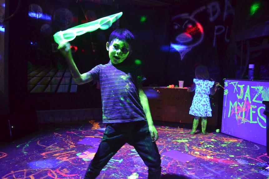 Myles Scharf plays with glow sticks at his father Julian's party.