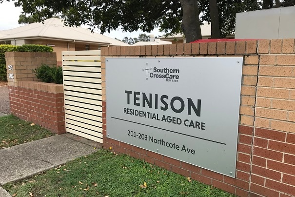 A sign on a brick wall that reads "Tenison residential aged care".