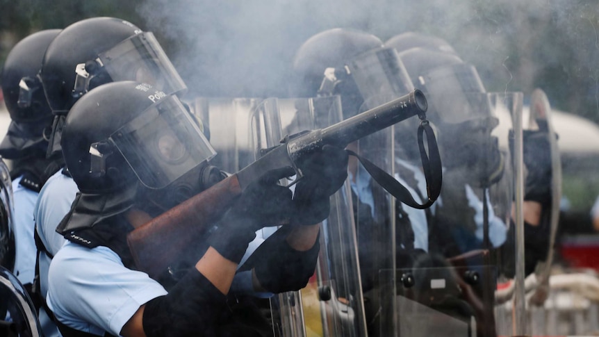 A police officer fires tear gas at protesters during a demonstration against a proposed extradition bill in Hong Kong.