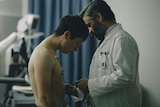 Still image of Barry Keoghan and Colin Farrell facing each other in a hospital room in 2017 film The Killing of a Sacred Deer