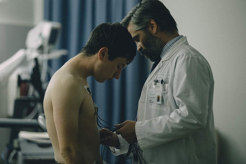 Still image of Barry Keoghan and Colin Farrell facing each other in a hospital room in 2017 film The Killing of a Sacred Deer