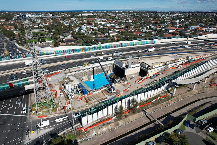 An aerial view of a complex construction project beside the West Gate Freeway.