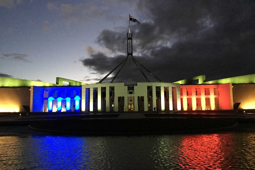 Parliament House in Canberra is lit in the blue, white and red of the French Tricolore.